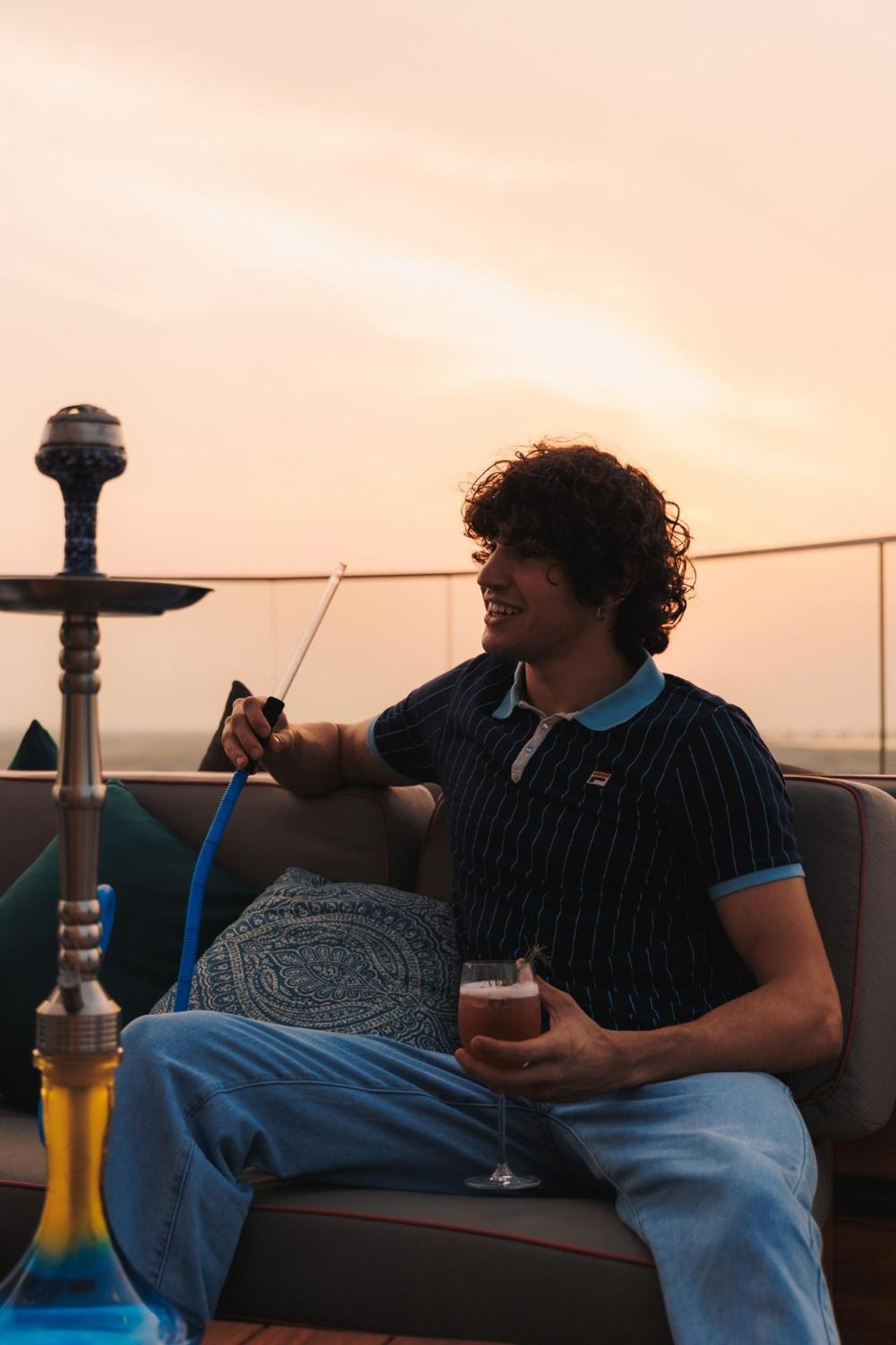 Ja The Resort - Ja Lake View Hotel, Dubai Luaran gambar A man smoking a hookah